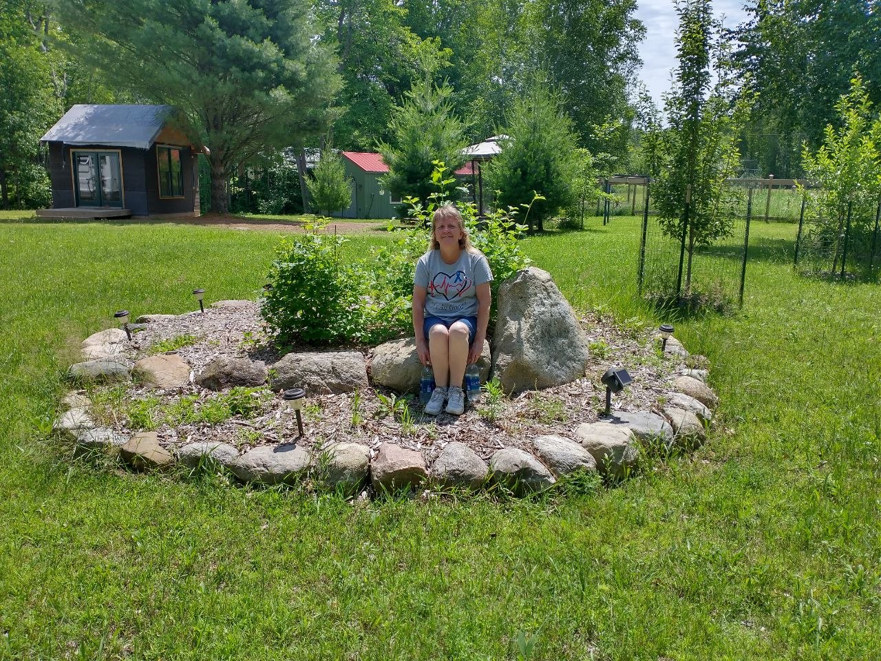Vanessa sitting in the rock bed area at the cabin property