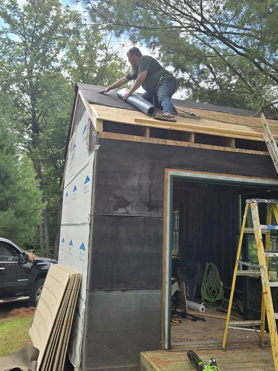 Jeff up on the roof working on the storage building in late summer 2025