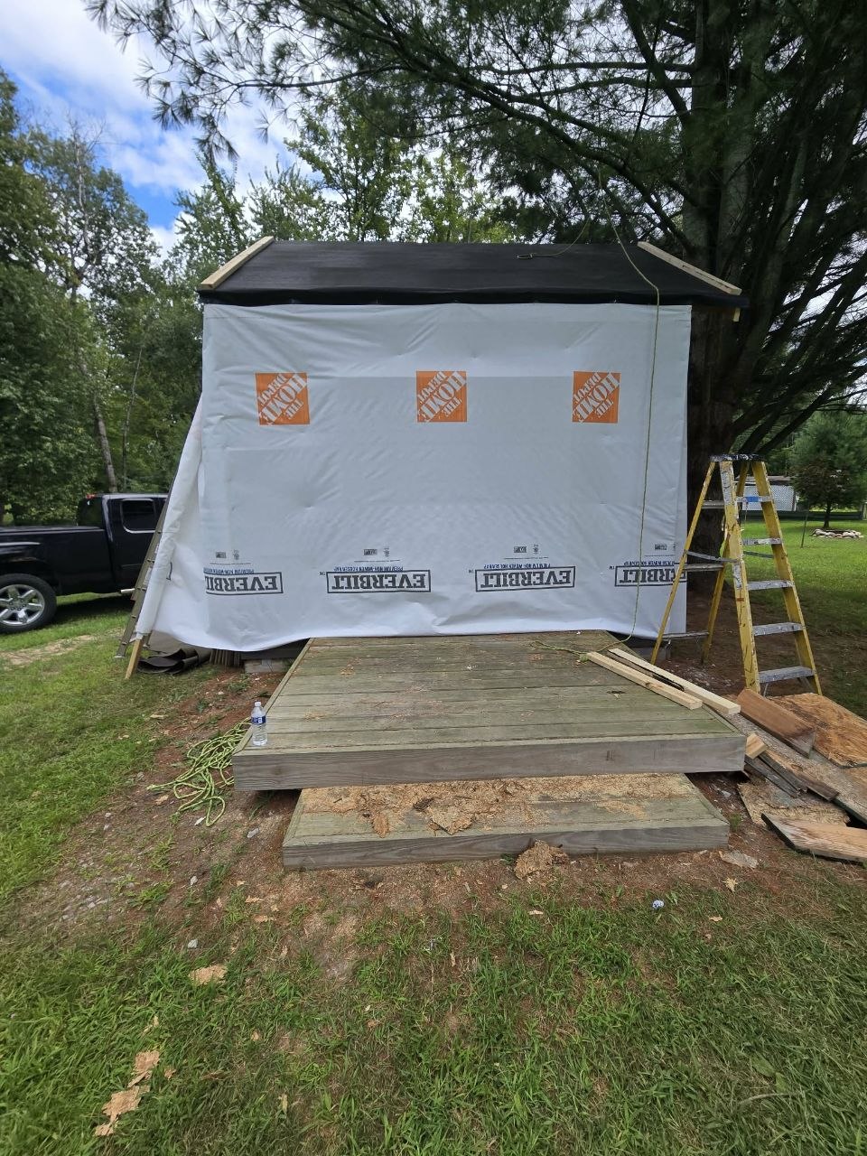 Storage building temporarily protected with house wrap during the weather-tight save phase
