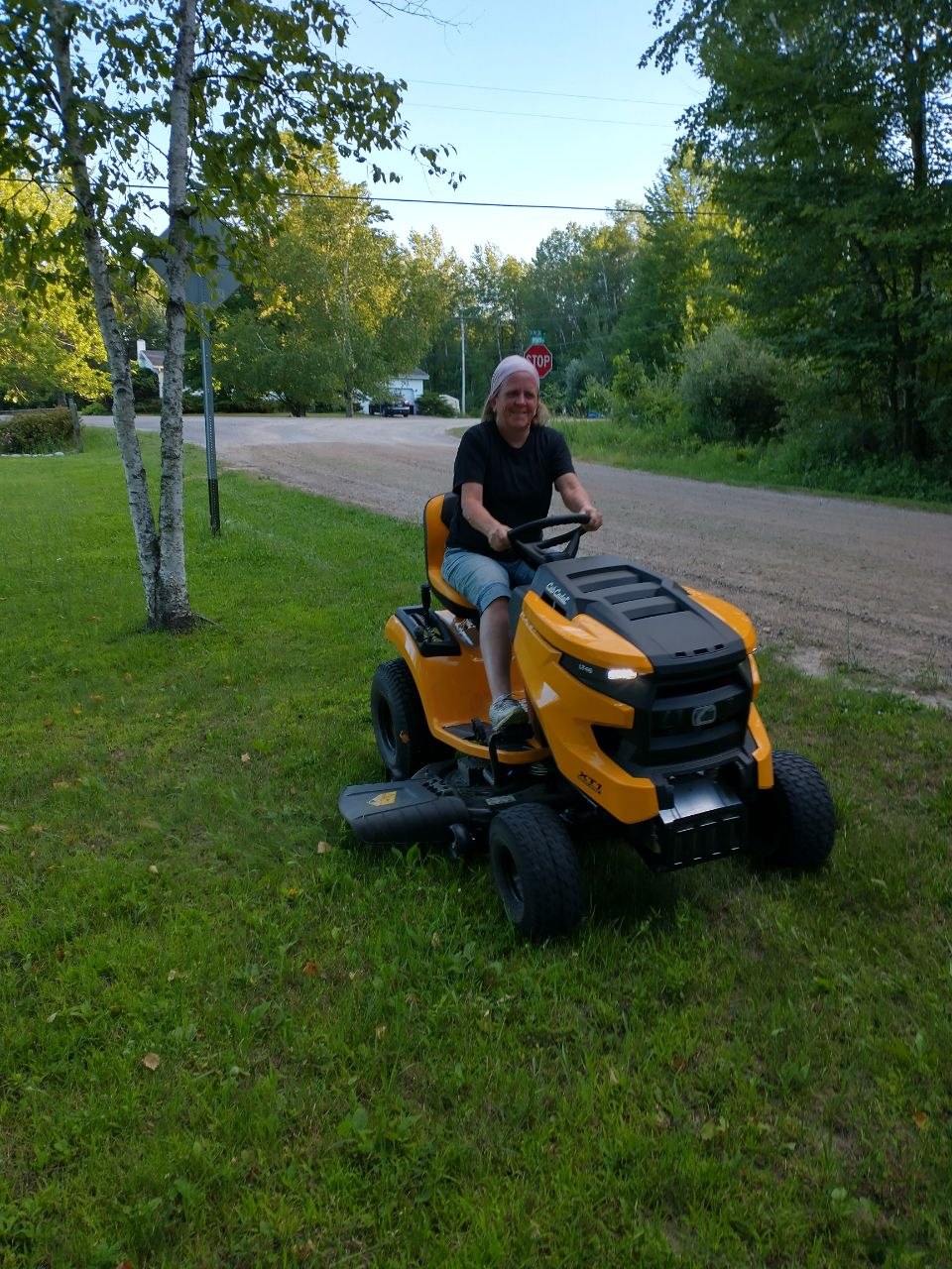 Vanessa trying out the Cub Cadet 46 inch deck riding lawn mower at the cabin