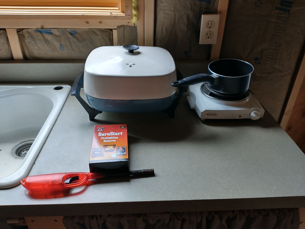Simple early cabin cooking setup with hot plate and basic gear