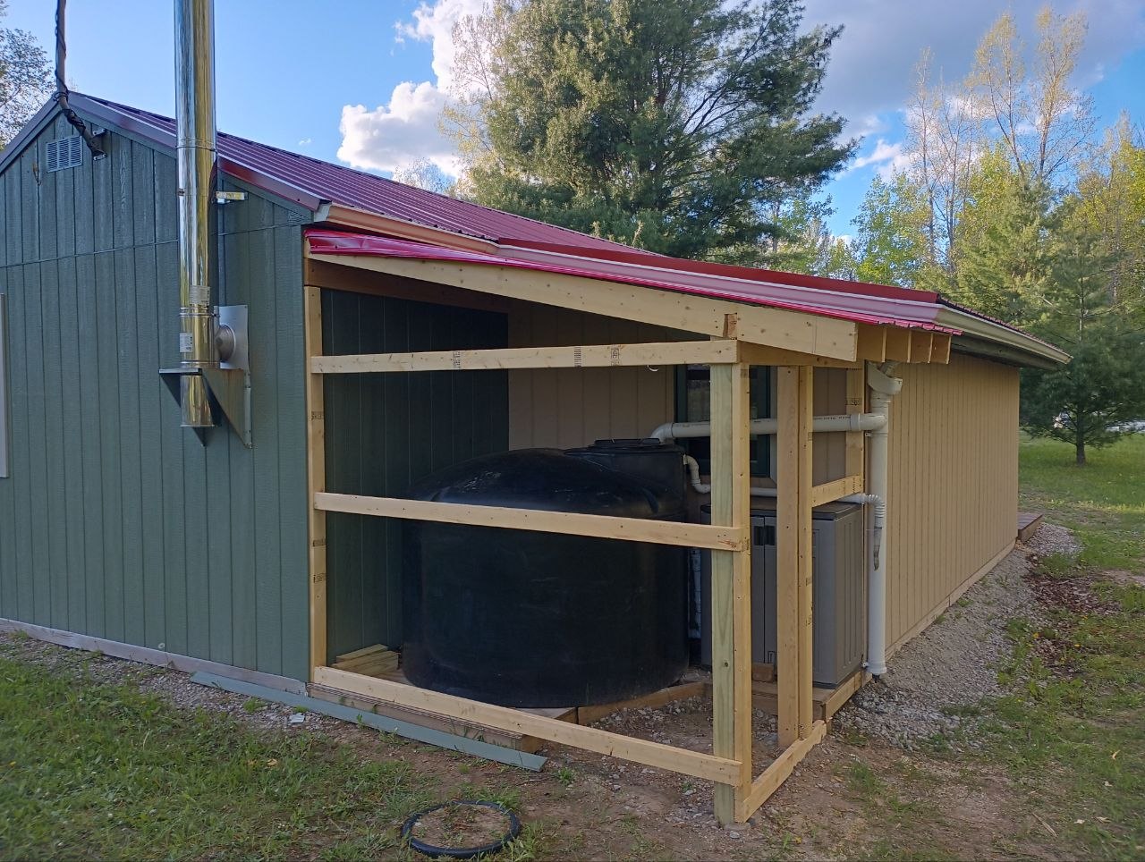 Finished enclosure built around the 500 gallon water tank beside the cabin