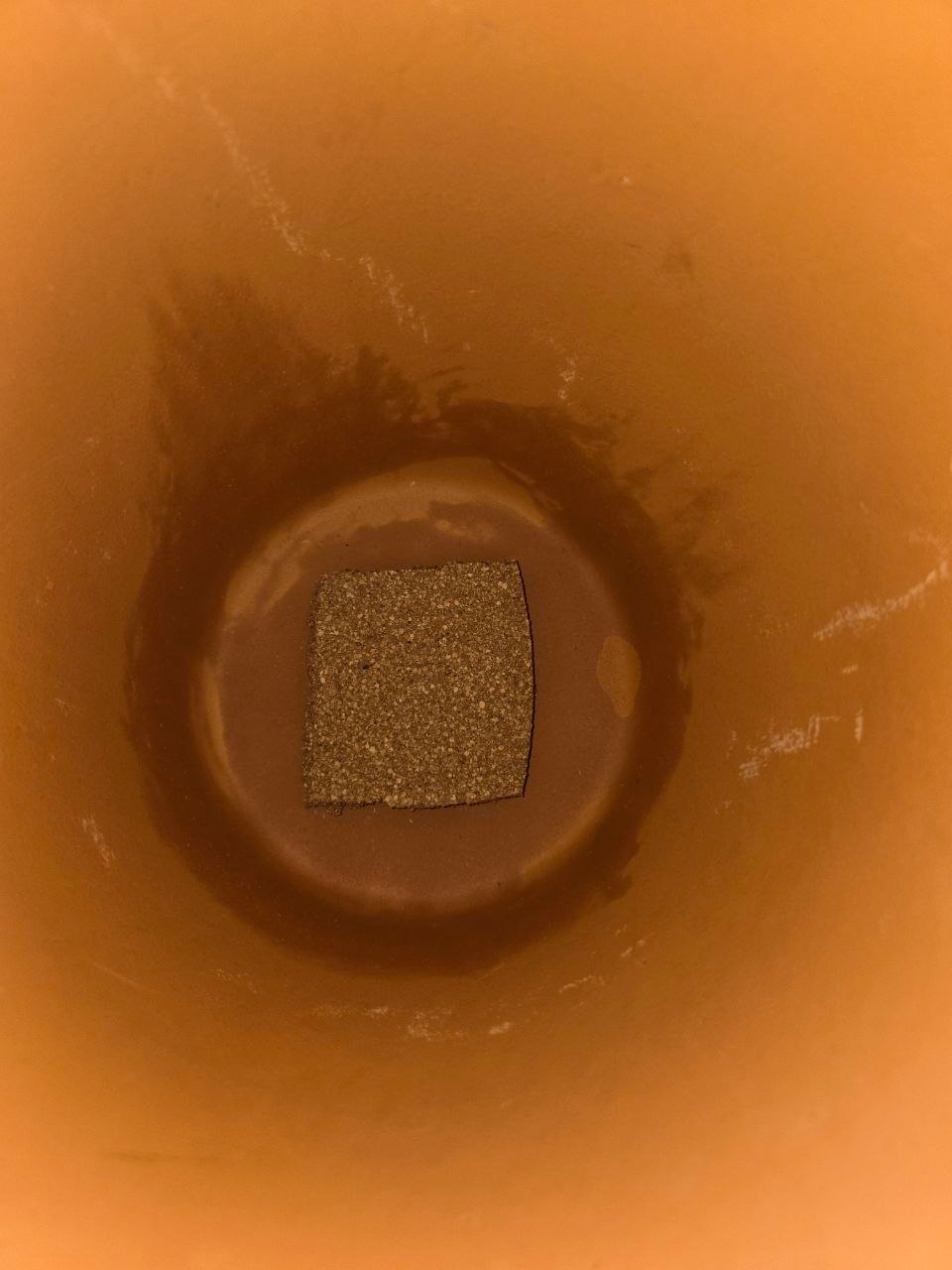 Close view of the plugged drain hole inside the pot